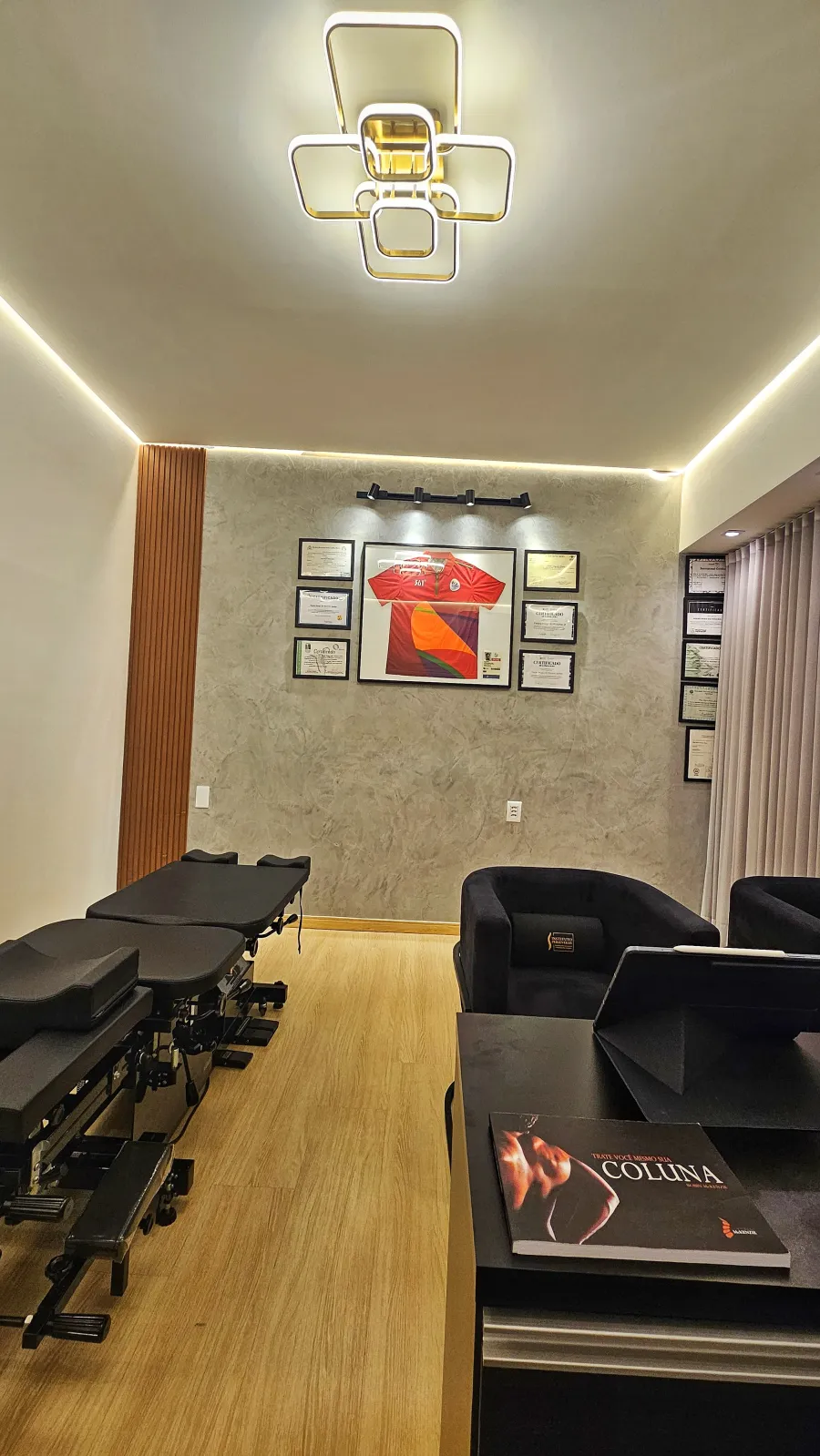 Sala de atendimento do Instituto Perseverar com macas de quiropraxia e certificados na parede